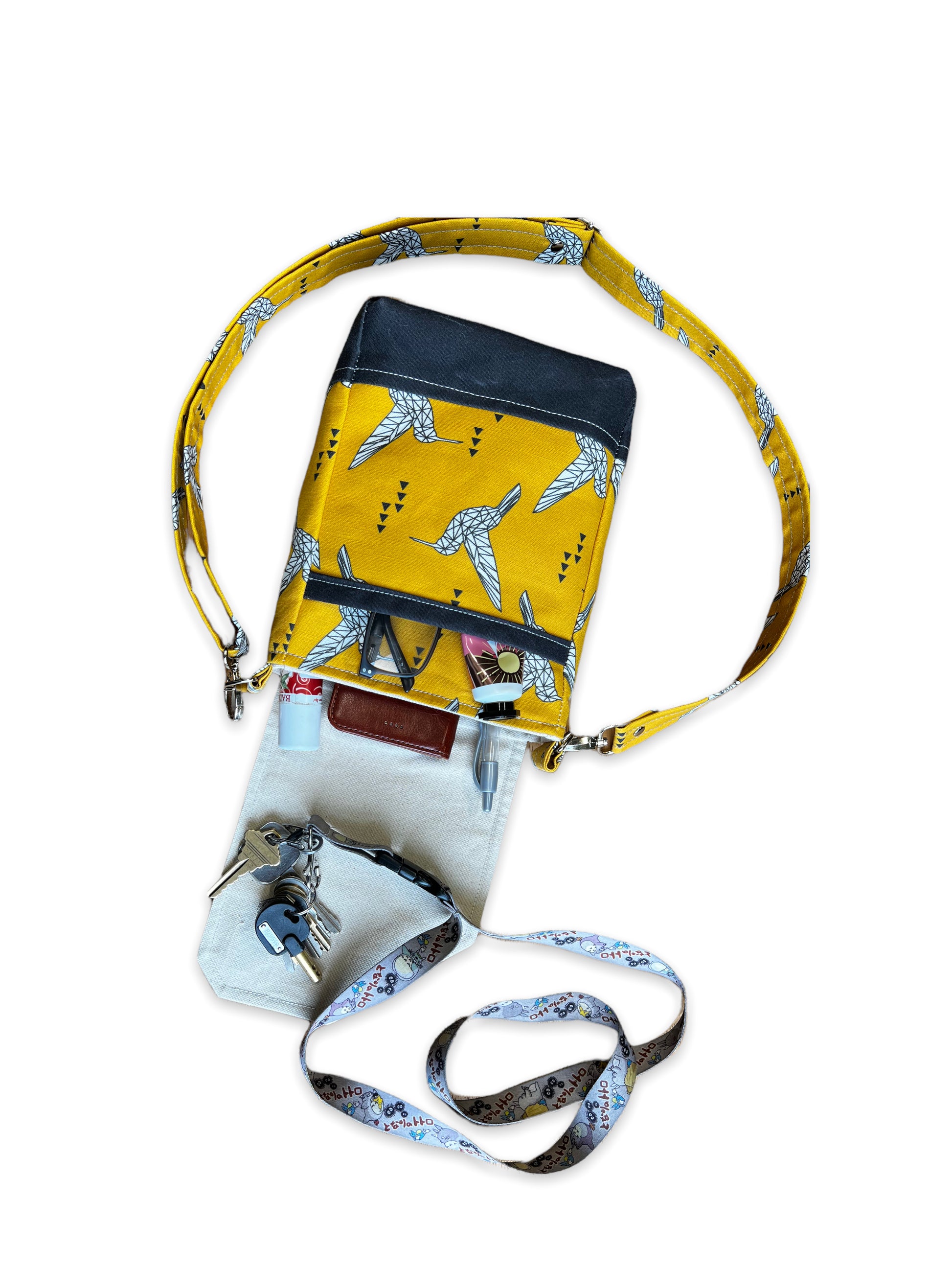 View of yellow purse open on table with contents spilling out.