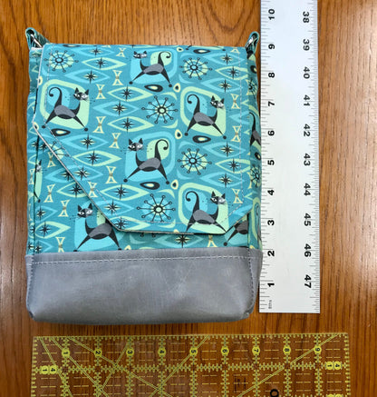 Cat print purse featuring midcentury atomic design with magnetic closure, two pockets, and a main compartment. Bag size is 8.5" x 6" x 3".