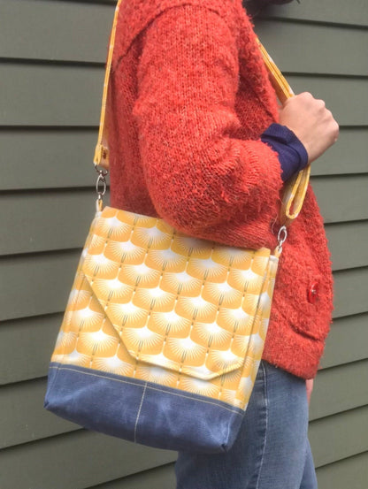 Art deco swan print purse featuring an adjustable strap, roomy interior, and five pockets! Cotton and waxed navy corduroy. Rich goldenrod color.