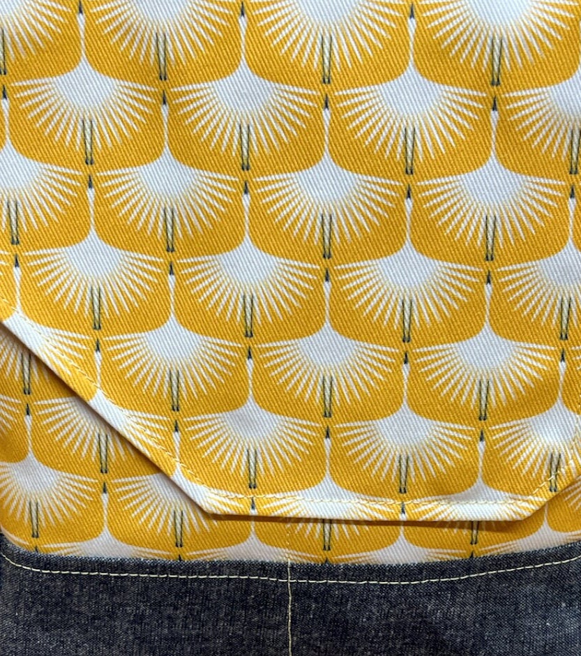 Art deco swan print purse featuring an adjustable strap, roomy interior, and five pockets! Cotton and waxed navy corduroy. Rich goldenrod color.
